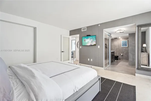 a spacious bedroom with a bed and a view of bathroom