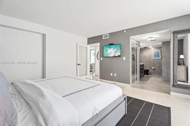 a spacious bedroom with a bed and a view of bathroom