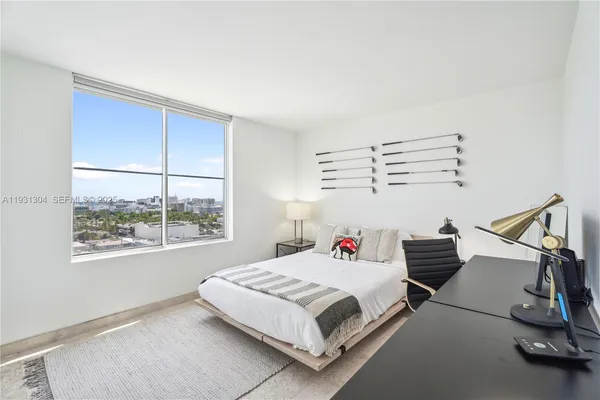 a bedroom with a bed next to a window