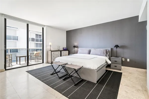 a bedroom with a bed a table and window