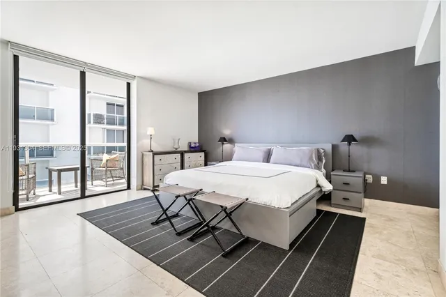 a bedroom with a bed a table and window