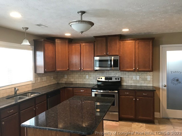 3331 Thrower Road Hope Mills, NC 28348 - Photo 8 of 25 a kitchen with stainless steel appliances granite countertop a sink stove and microwave
