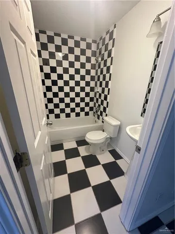 a bathroom with a black and white checkered floor