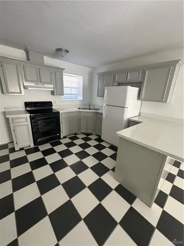 a kitchen with a checkered floor and white cabinets