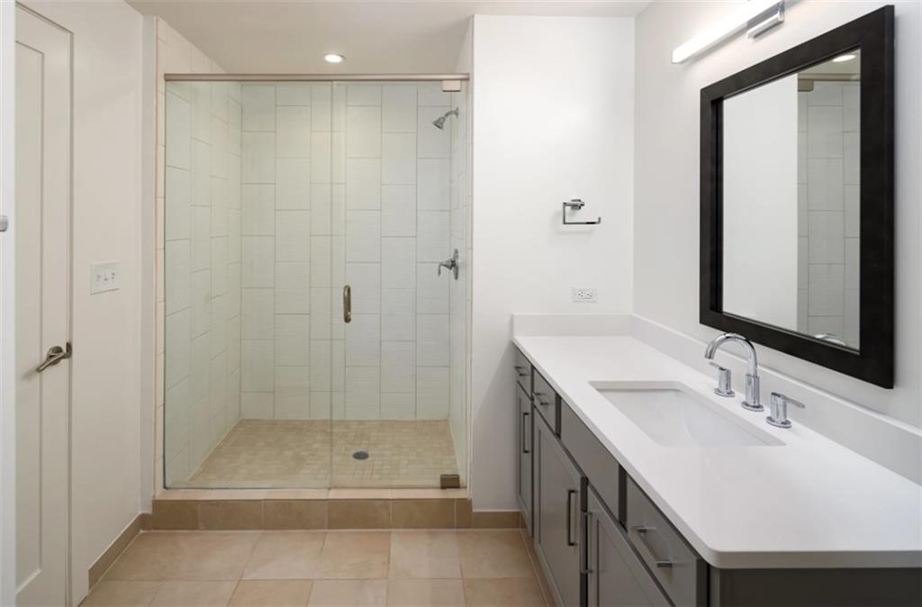 3242 Peachtree Road Northeast, Unit 301 Atlanta, GA 30305 - Photo 18 of 41 a bathroom with a shower a sink and a mirror