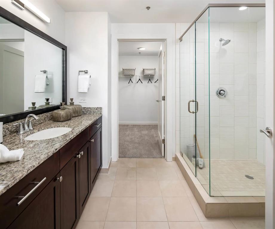 3242 Peachtree Road Northeast, Unit 301 Atlanta, GA 30305 - Photo 20 of 41 a spacious bathroom with a granite countertop sink mirror and shower