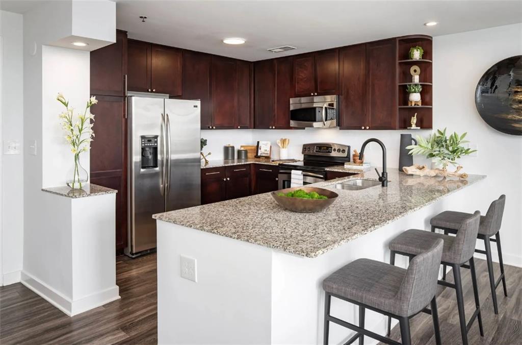 3242 Peachtree Road Northeast, Unit 301 Atlanta, GA 30305 - Photo 2 of 41 a kitchen with stainless steel appliances granite countertop a refrigerator a stove a sink a dining table and chairs