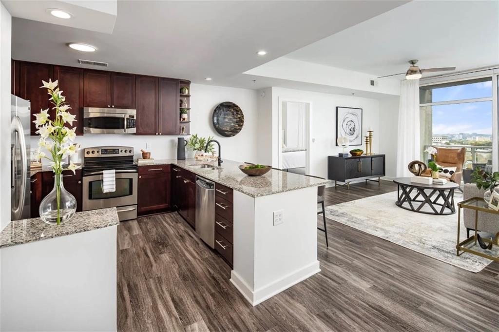 3242 Peachtree Road Northeast, Unit 301 Atlanta, GA 30305 - Photo 3 of 41 a kitchen with stainless steel appliances granite countertop a stove top oven a sink dishwasher a dining table and chairs with wooden floor
