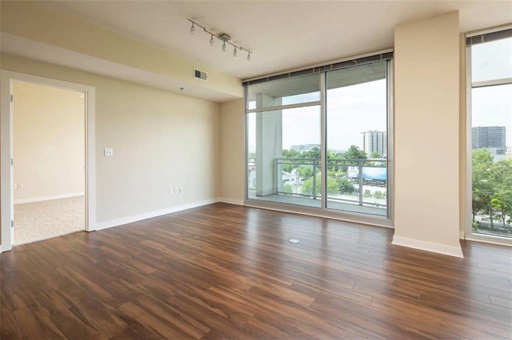 3242 Peachtree Road Northeast, Unit 301 Atlanta, GA 30305 - Photo 8 of 41 a view of empty room with wooden floor and fan