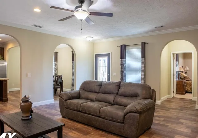 a living room with furniture and a wooden floor