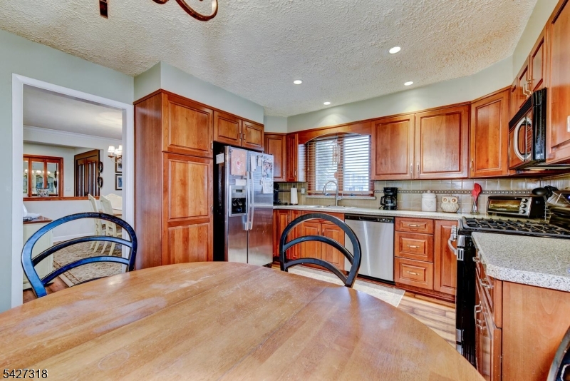 52 Ashburn Road Wayne, NJ 07470 - Photo 21 of 49 a kitchen with stainless steel appliances granite countertop a refrigerator a stove top oven a sink and a large window