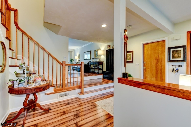 52 Ashburn Road Wayne, NJ 07470 - Photo 10 of 49 a view of a hallway with wooden floor and furniture