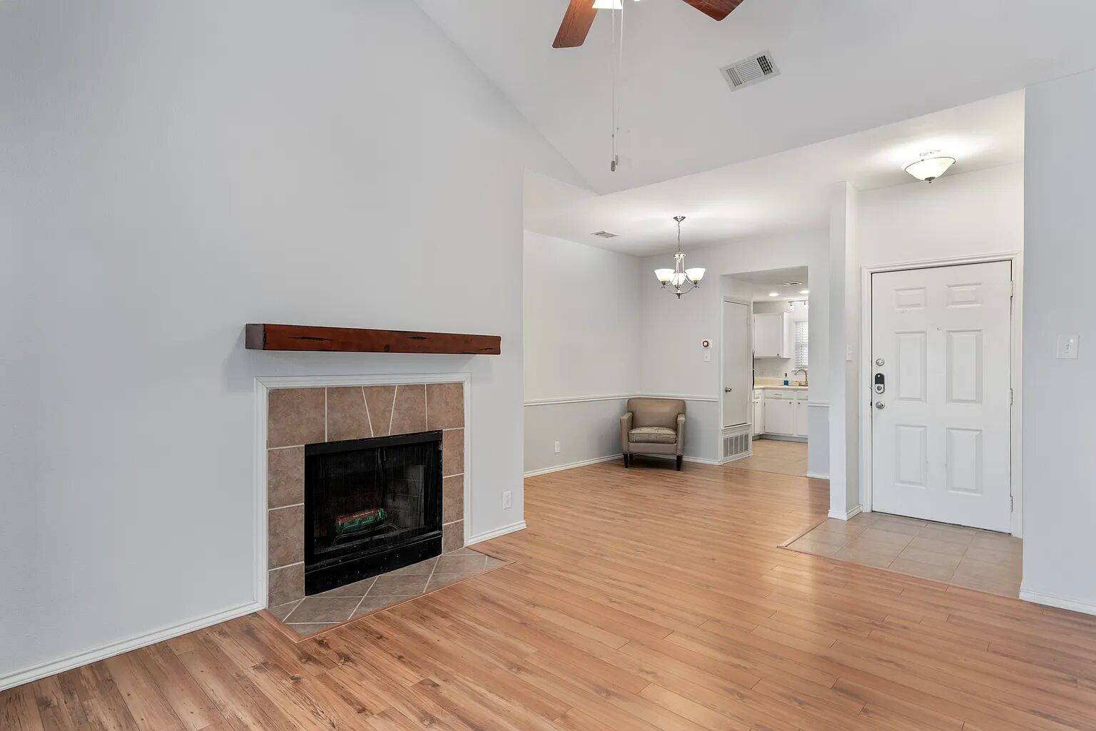 11970 Jollyville Road, Unit 202 Austin, TX 78759 - Photo 4 of 25 A well-lit living area features a charming fireplace with a wooden mantle and gleaming wood floors.
