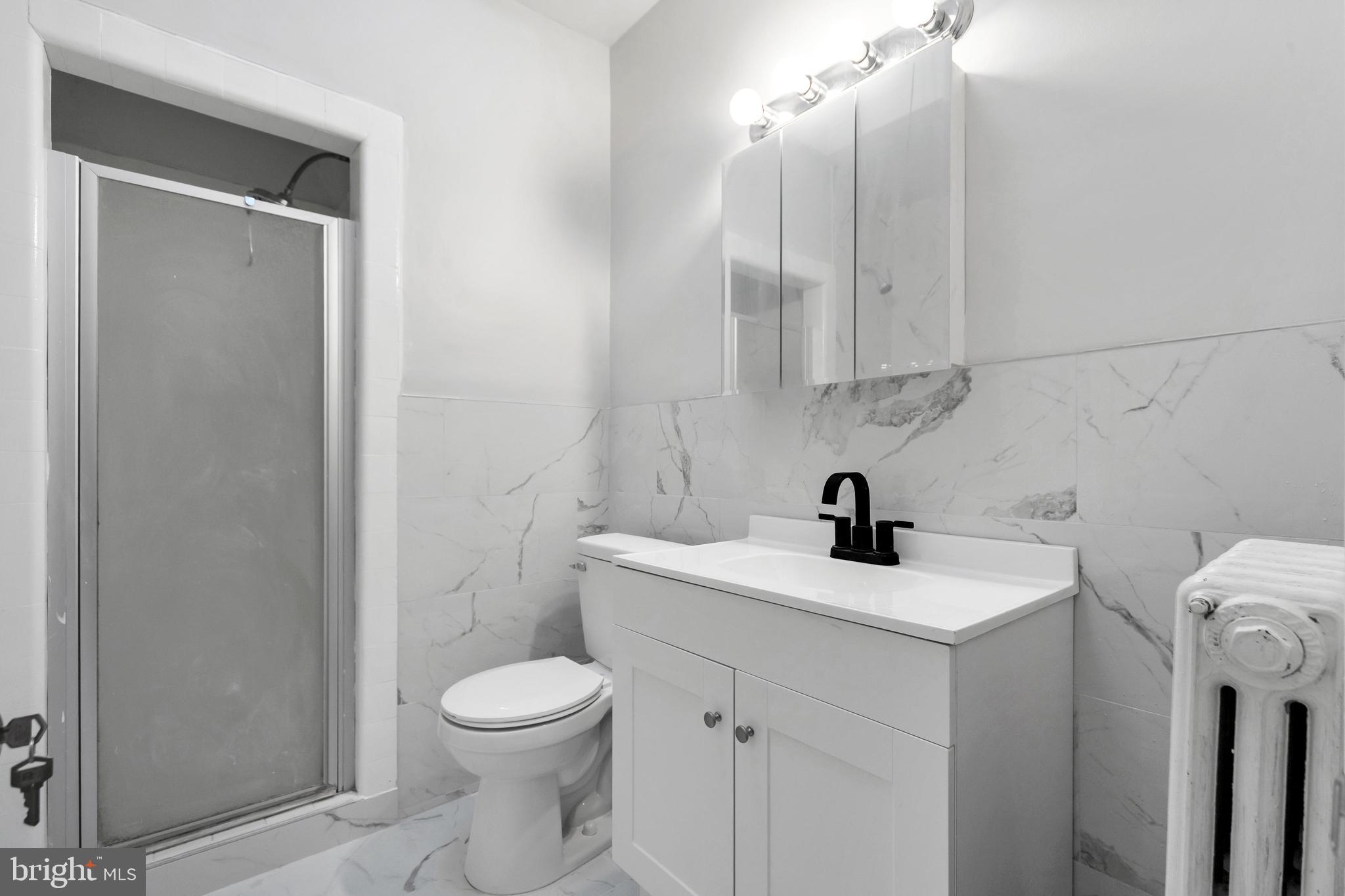 244 Wembly Road Upper Darby, PA 19082 - Photo 12 of 26 a bathroom with a sink a toilet and a mirror