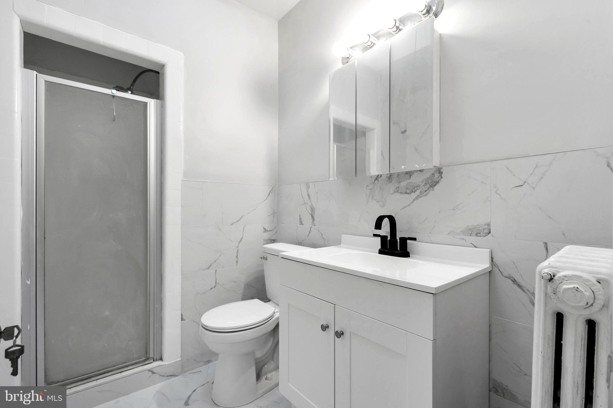 244 Wembly Road Upper Darby, PA 19082 - Photo 17 of 26 a bathroom with a sink a toilet and a mirror