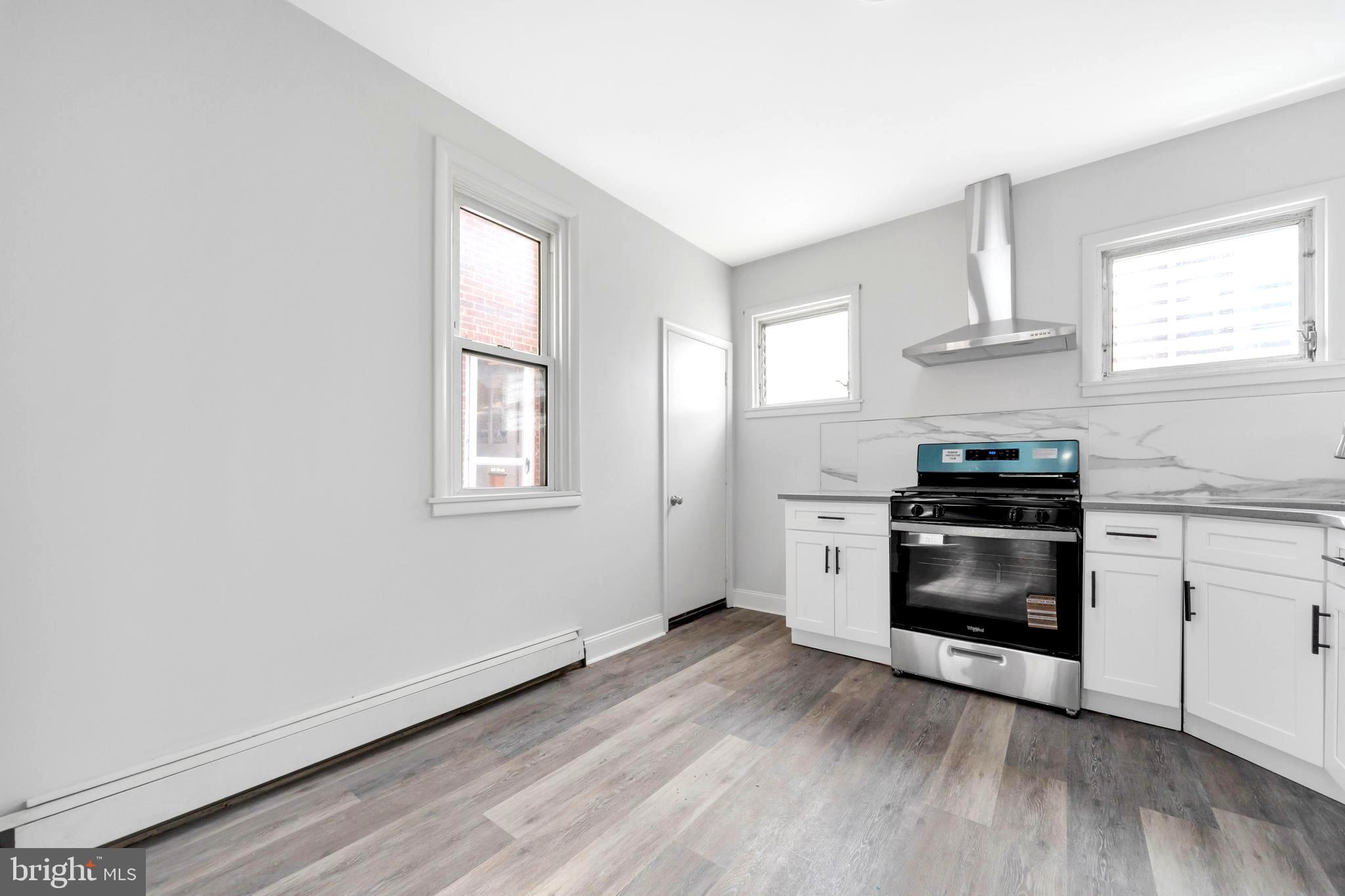 244 Wembly Road Upper Darby, PA 19082 - Photo 18 of 26 a kitchen with granite countertop a stove and a window
