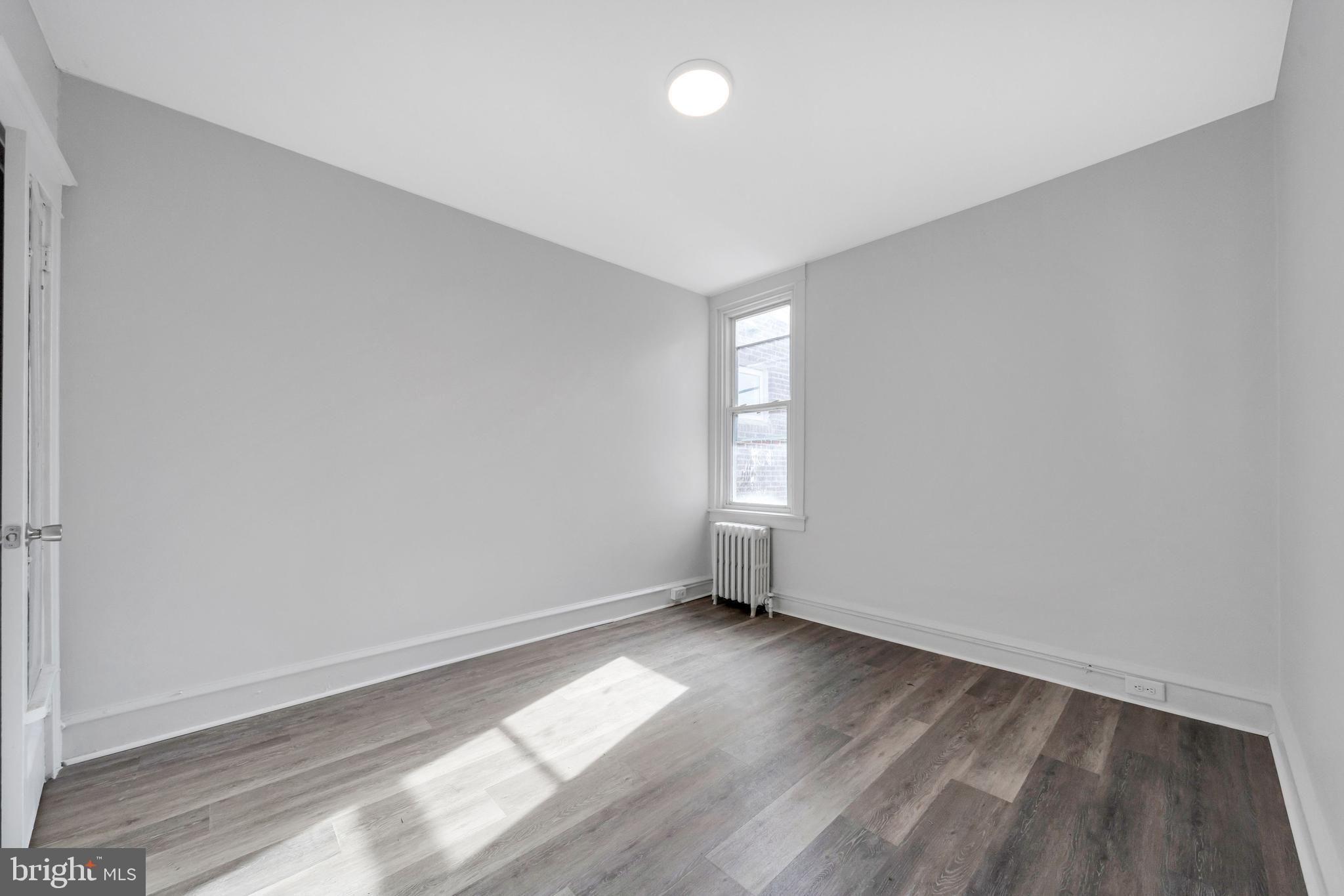 244 Wembly Road Upper Darby, PA 19082 - Photo 8 of 26 an empty room with wooden floor and windows