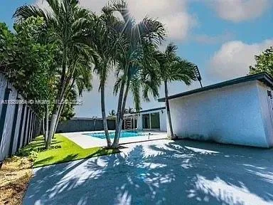 a view of swimming pool with palm trees