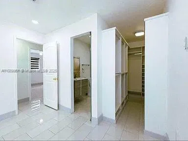 a view of a hallway with closet and bathroom