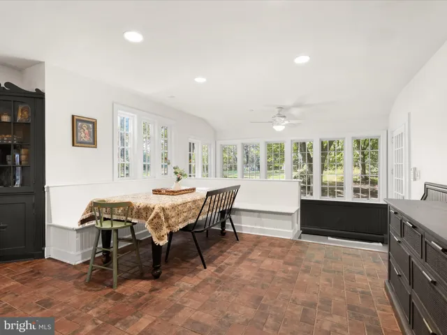 a dining room with furniture wooden floor a rug and a chandelier