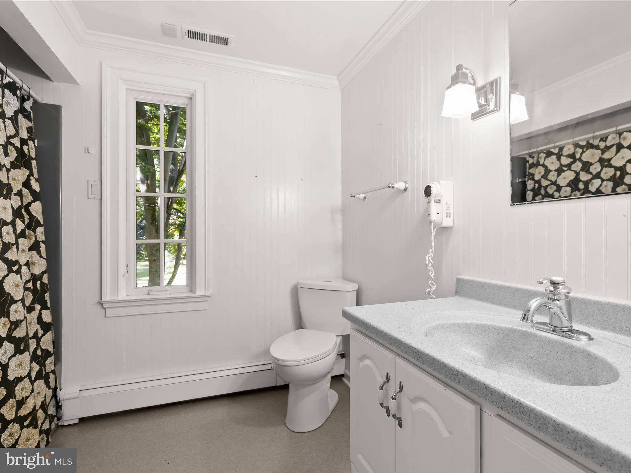 5708 Emory Road Upperco, MD 21155 - Photo 55 of 78 a bathroom with a granite countertop toilet a sink a mirror and a window