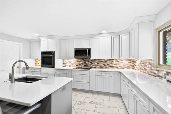 a kitchen with stainless steel appliances kitchen island granite countertop a table and chairs in it