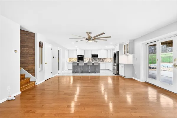 a view of empty room with wooden floor and floor to ceiling window