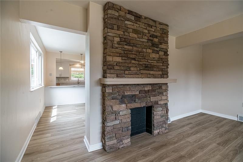 925 Greenhill Road Pittsburgh, PA 15209 - Photo 8 of 27 an empty room with wooden floor a fireplace and windows