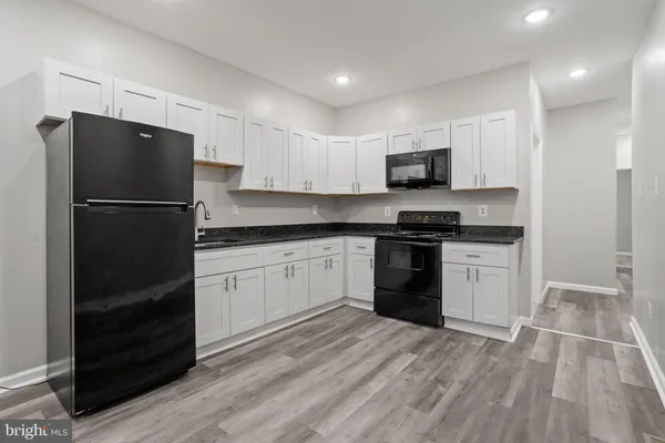 a kitchen with a refrigerator and a stove top oven