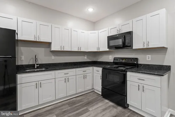 a kitchen with granite countertop white cabinets and stainless steel appliances