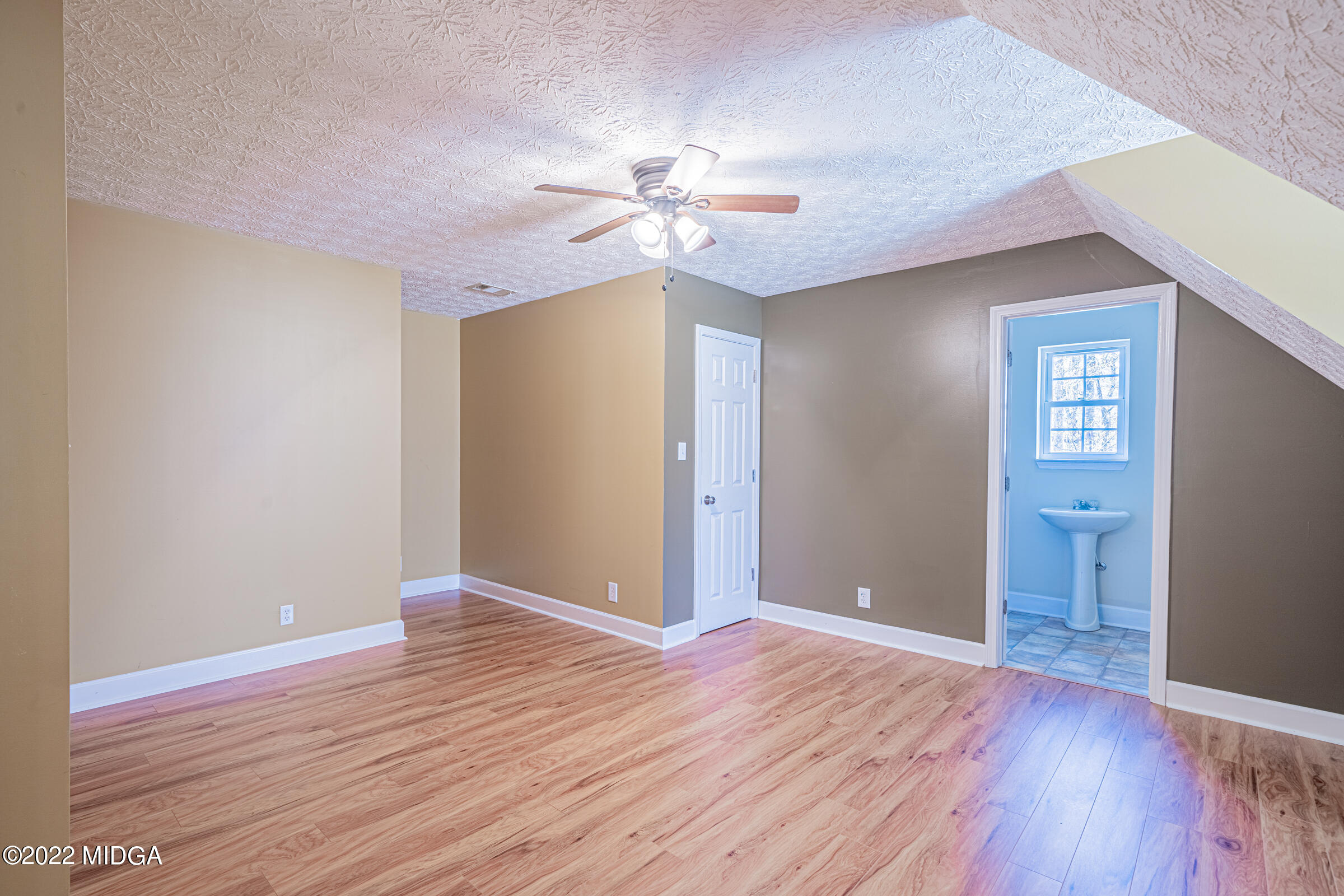229 Howard Roberts Road Gray, GA 31032 - Photo 18 of 28 a view of an empty room with window and wooden floor
