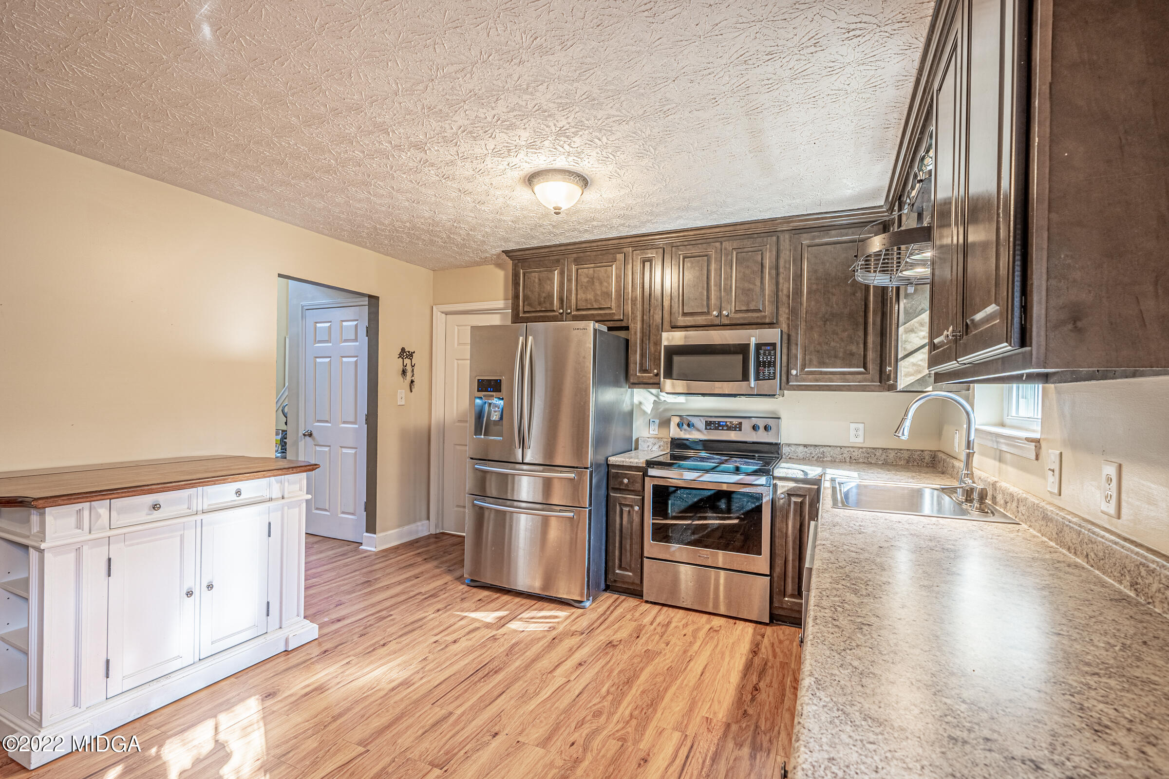 229 Howard Roberts Road Gray, GA 31032 - Photo 5 of 28 a kitchen with stainless steel appliances granite countertop a refrigerator oven a sink dishwasher and white cabinets with wooden floor