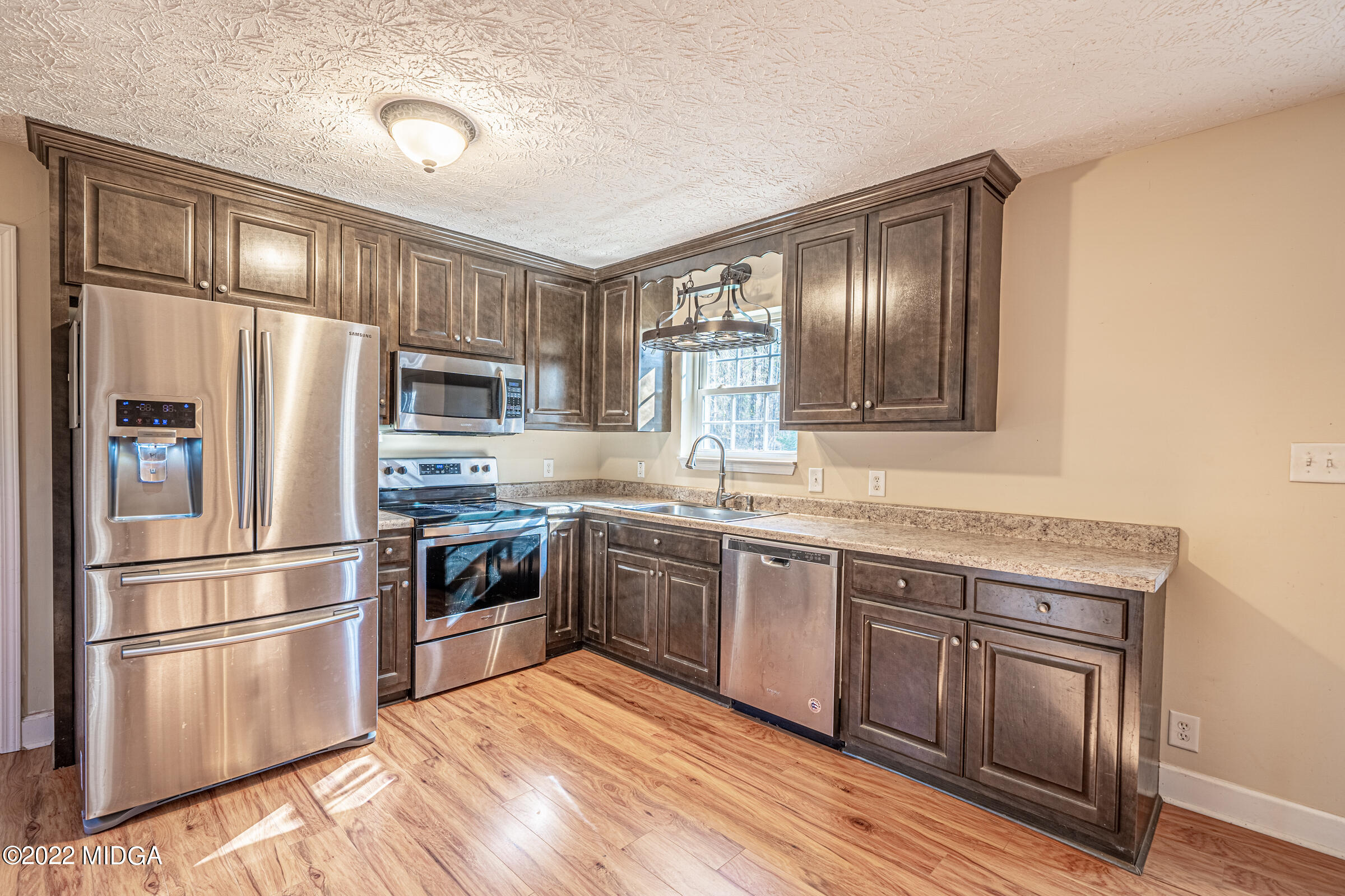 229 Howard Roberts Road Gray, GA 31032 - Photo 6 of 28 a kitchen with granite countertop stainless steel appliances and wooden cabinets