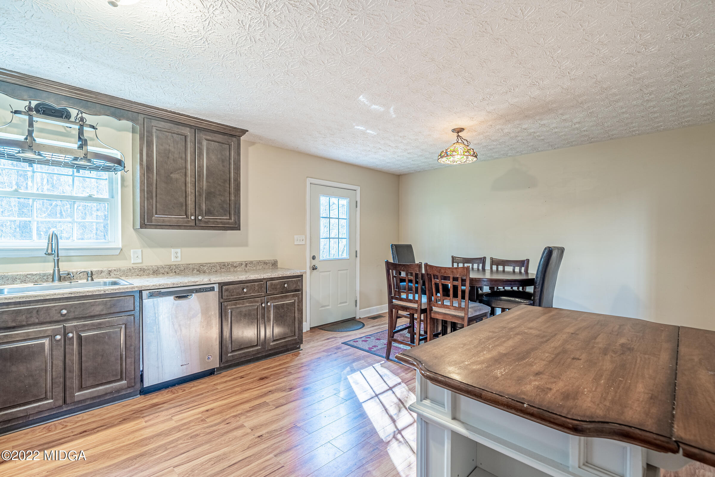 229 Howard Roberts Road Gray, GA 31032 - Photo 7 of 28 a kitchen with a stove a sink dishwasher a dining table and chairs with wooden floor