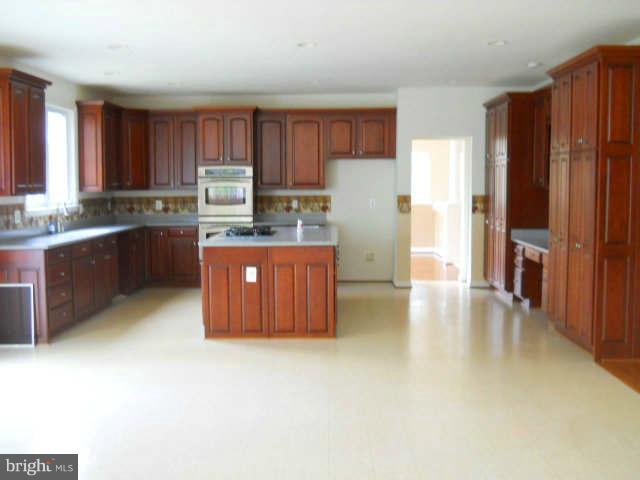 2375 Mountain Road Haymarket, VA 20169 - Photo 7 of 19 a kitchen with stainless steel appliances granite countertop a refrigerator a stove a sink dishwasher and wooden cabinets with wooden floor