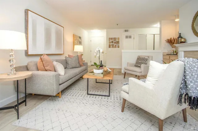 a living room with furniture and a large mirror next to a window