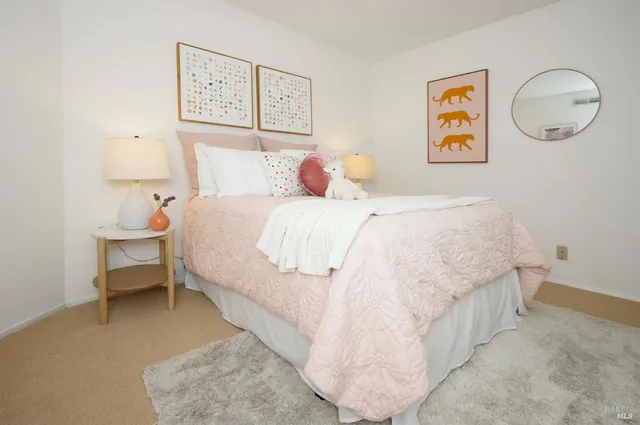 a bedroom with a bed and painting on the wall