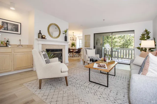 a living room with furniture a fireplace and a large window