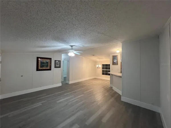 an empty room with wooden floor and cabinet
