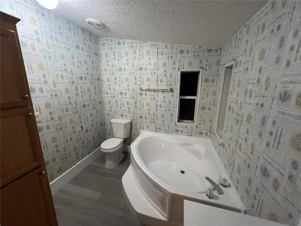 a bathroom with a granite countertop sink a toilet and a shower