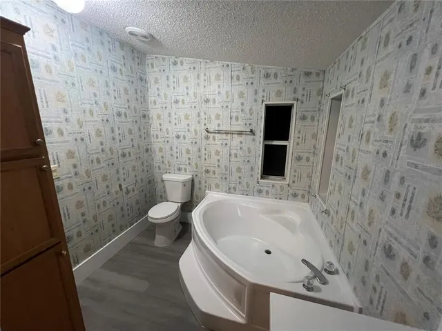 a bathroom with a granite countertop sink a toilet and a shower