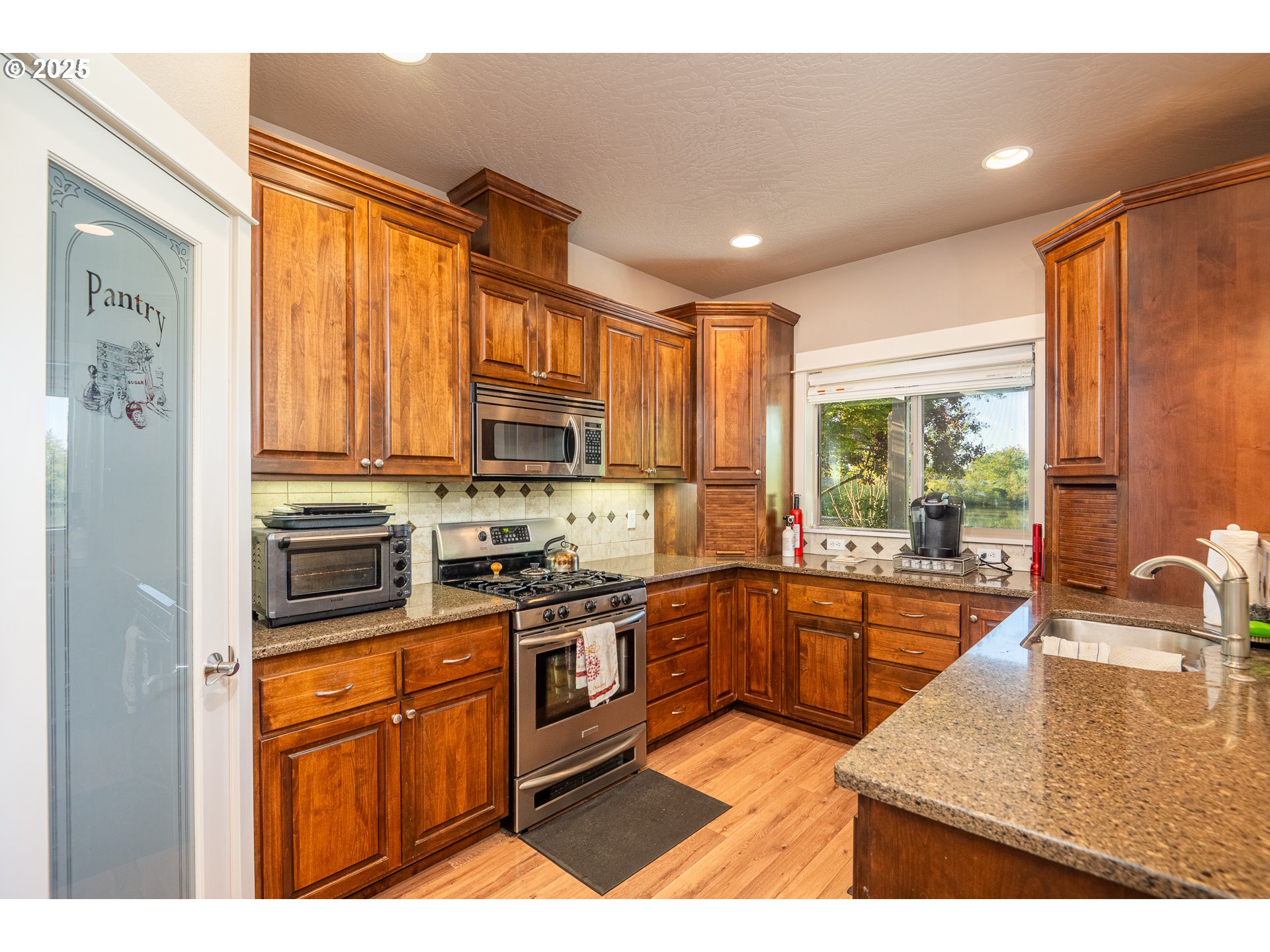 4756 Jessen Drive Eugene, OR 97402 - Photo 13 of 29 a kitchen with stainless steel appliances granite countertop a stove a sink and a microwave
