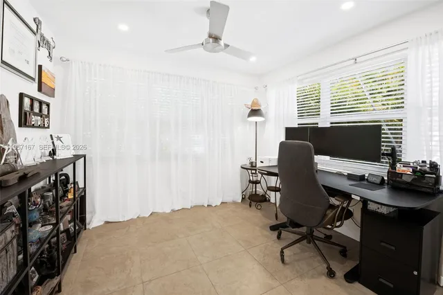 a view of a workspace with furniture and a window