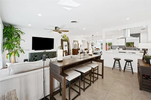 a kitchen with stainless steel appliances kitchen island granite countertop a table and chairs in it