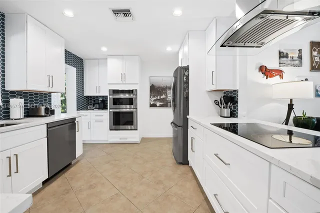 a large kitchen with stainless steel appliances kitchen island granite countertop a sink and cabinets