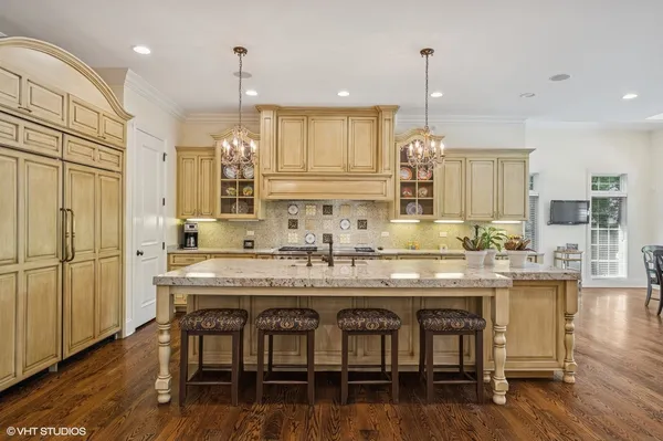 a large kitchen with kitchen island a large island in it