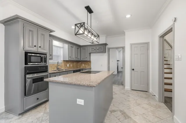 a kitchen with stainless steel appliances granite countertop a sink a stove and refrigerator