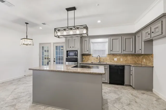 a kitchen with stainless steel appliances granite countertop a sink a stove a refrigerator and cabinets