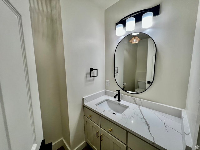 812 East Bates Cyn Road Tooele, UT 84074 - Photo 51 of 144 Modern vanity with a white rectangular undermount sink, a stone-finish countertop, and a matte black faucet