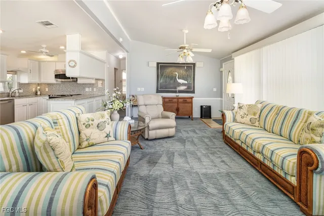 a living room with furniture kitchen and a chandelier